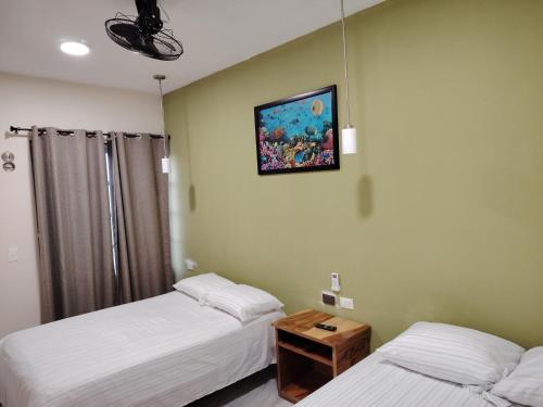 a room with two beds and a picture on the wall at Depa Caribe III in Bacalar