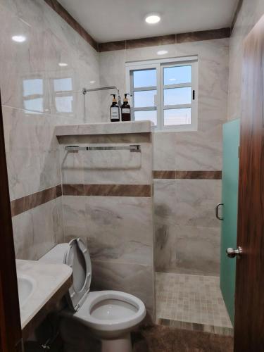 a bathroom with a toilet and a sink and a window at Depa Caribe III in Bacalar