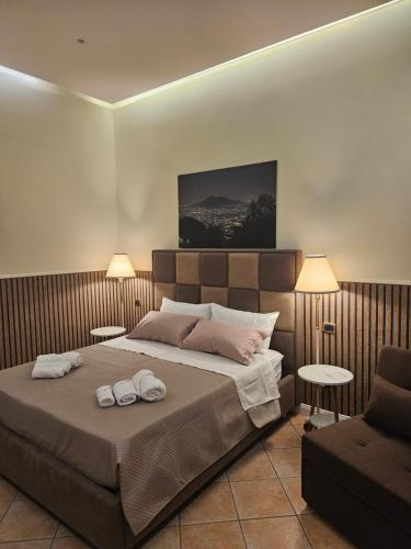 a bedroom with a large bed and a chair at Corte26 in Nocera Inferiore