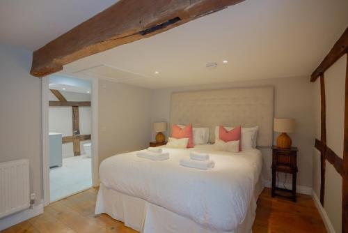 a bedroom with a large white bed with orange pillows at Characterful Home Steps from Cathedral in Hereford