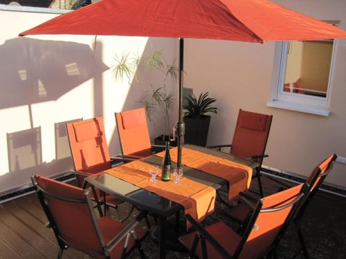een eettafel met een rode paraplu bij B&U Fewo Scherhag in Alken