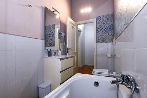 a bathroom with a tub and a toilet and a sink at Dimora Cavour 1810 in Civitavecchia