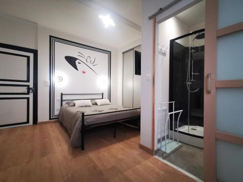 a bedroom with a bed and a glass shower at Maillas D'en Haut in LʼIsle-en-Dodon