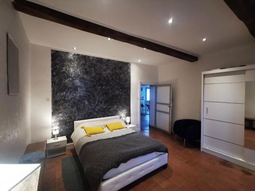 a bedroom with a bed with two yellow pillows at Maillas D'en Haut in LʼIsle-en-Dodon