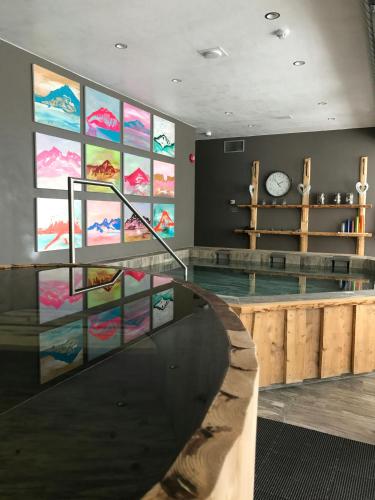 a gym with a swimming pool with paintings on the wall at Gistihúsið - Lake Hotel Egilsstadir in Egilsstaðir