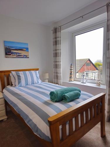 a bedroom with a bed with a large window at Railway Cottage, Liskeard in Liskeard