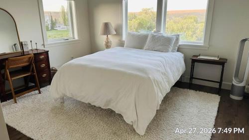 a bedroom with a large white bed with a window at The Llama Lane House in Yakima