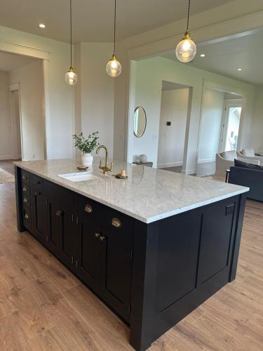 a kitchen with a large black island with a sink at The Llama Lane House in Yakima