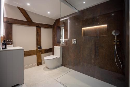 a bathroom with a shower and a toilet and a sink at Characterful Home Steps from Cathedral in Hereford