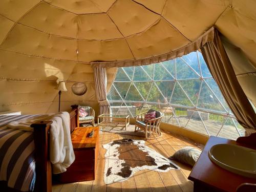a bedroom in a dome tent with a large window at Diana's Place in Moeraki