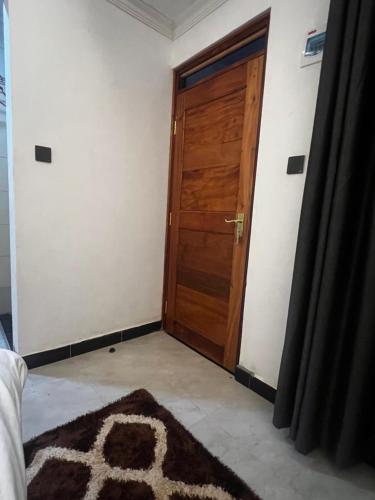 a room with a wooden door and a rug at Kithumulani Resort in Tiva