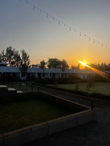 a sunset view of a building with the sun setting at Kithumulani Resort in Tiva