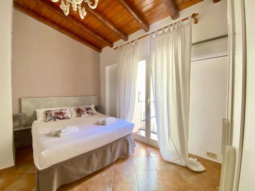 a bedroom with a bed and a large window at Tao House in Taormina
