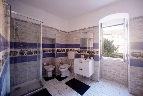 a bathroom with a toilet and a shower and a sink at zahira in Biassa