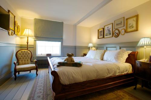 a teddy bear sitting on a bed in a bedroom at The Duchess of Cornwall in Dorchester