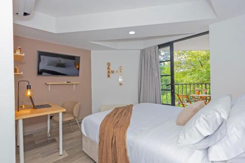 a hotel room with a bed and a desk and a window at Bit Building in Medellín
