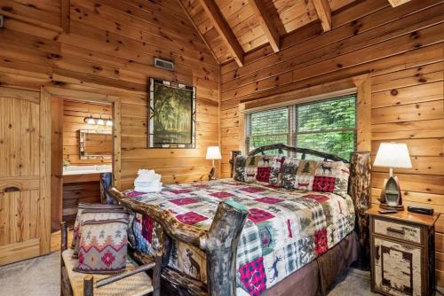 a bedroom with a bed in a log cabin at Scenic Serenity #75 by Venture Smoky Mountains in Sevierville