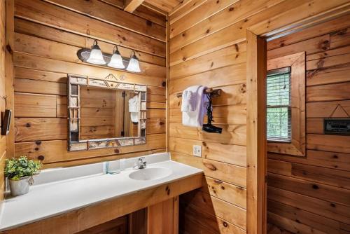 a bathroom with a sink and a mirror at Scenic Serenity #75 by Venture Smoky Mountains in Sevierville