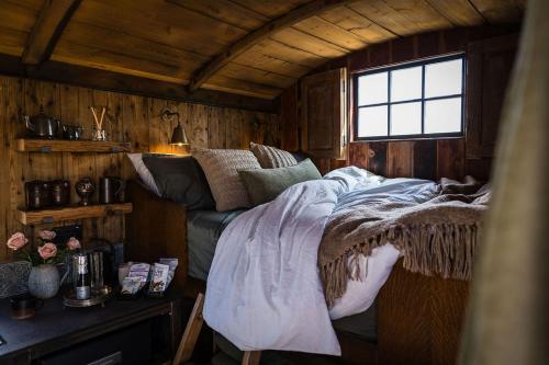 a bedroom with a bed in a wooden cabin at The 450 from Paddington in Bourton on Dunsmore