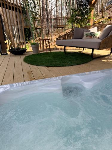 a hot tub with a bench in a backyard at Treeangle Treehouse in Morganton