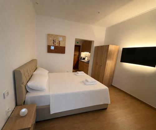 a small room with a bed and a flat screen tv at Prime 27 Luxury Studio in Lavrio