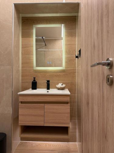 a bathroom with a sink and a mirror at Prime 27 Luxury Studio in Lavrio
