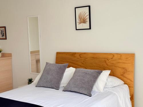 a white bed with two pillows on top of it at Exclusivo Apartamento Céntrico con Terraza Privada in Sogamoso