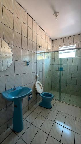 a bathroom with a blue sink and a toilet at Hotel Iung in Alfredo Wagner