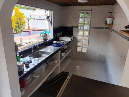 a kitchen with a sink and a large window at Casa Rotario Honda in Honda