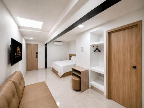 a room with a bed and a couch and a bedroom at Hotel Aikos in Yumbo