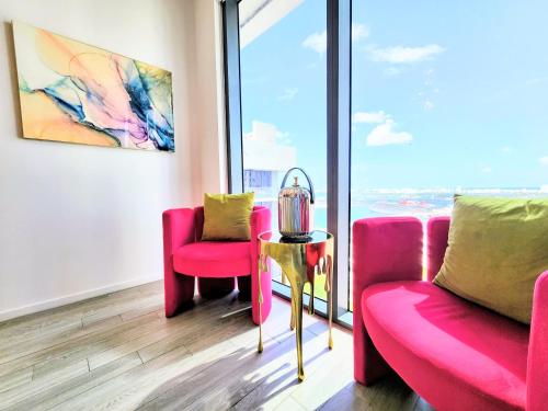 a room with pink chairs and a table and a window at Marina Miami Penthouse- Downtown-Brickell 2BD-2BA in Miami
