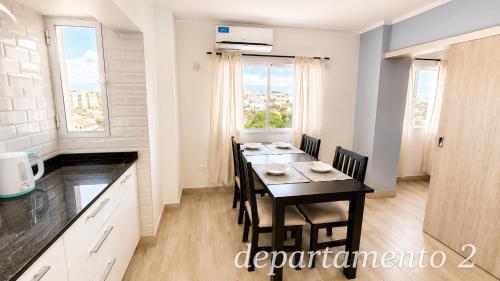 a kitchen with a dining room table with chairs at Nice Full Apartments Downtown Salta in Salta