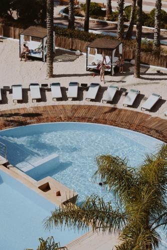 an overhead view of a swimming pool with lounge chairs at Aguas de Ibiza by NCalma Hotels in Santa Eularia des Riu