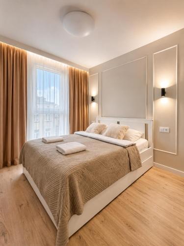 a bedroom with a large bed with a large window at Slovianka Residence - strefa spa oraz darmowy parking! in Łódź