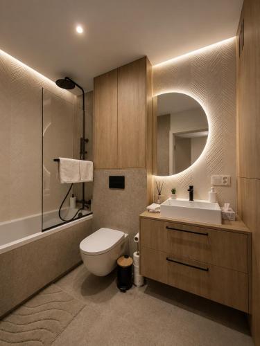 a bathroom with a sink and a toilet and a mirror at Slovianka Residence - strefa spa oraz darmowy parking! in Łódź