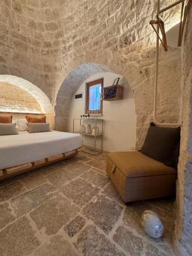 a bedroom with a bed and a couch at Trullidea in Alberobello