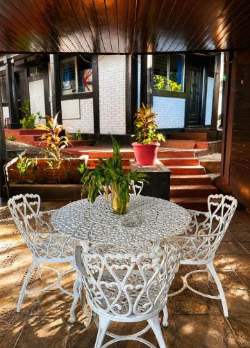 a white table and chairs with a potted plant on it at hotel Oasis Managua Experience - HOME in Managua