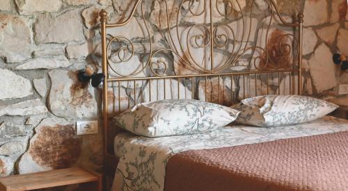 a bed with a metal head board and pillows at Filoxenia - The Place of Experience in Himare