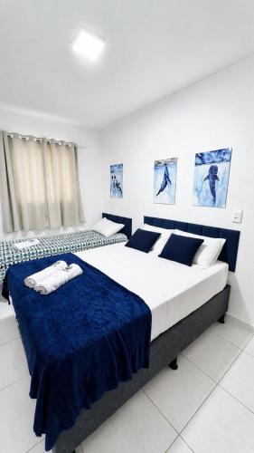 two beds in a bedroom with blue and white at Casa no centro de Ponta de Pedras - Casa da Baleia VILA ORION in Goiana