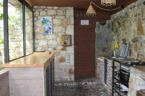 a kitchen with a counter and a stone wall at Filoxenia - The Place of Experience in Himare