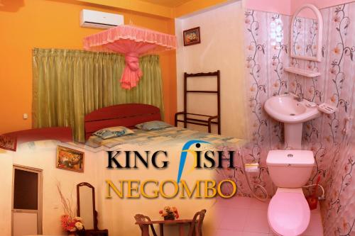 a bathroom with a bed and a sink and a toilet at King Fish Guest House in Negombo