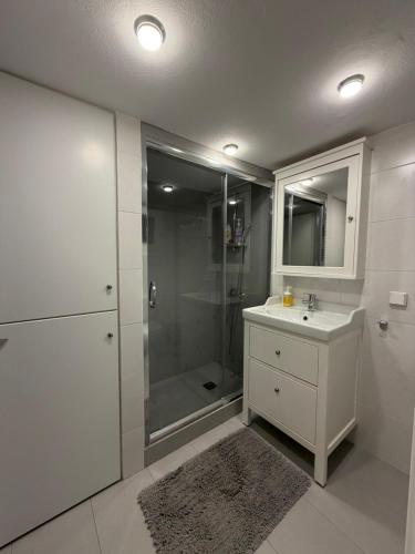 a white bathroom with a shower and a sink at City View Apartment in Mytilene