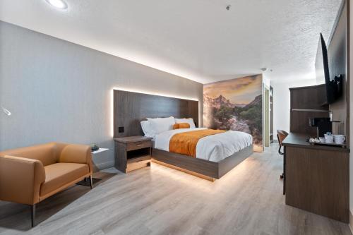 a hotel room with a bed and a chair at Zion Promenade Hotel in St. George