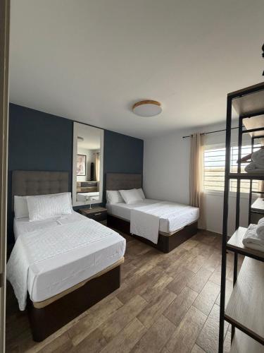 a bedroom with two beds and a mirror at Chalet Escapada in Seville