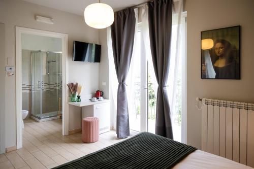 a bedroom with a bed and a large window at Hotel Rossovino Como in Como