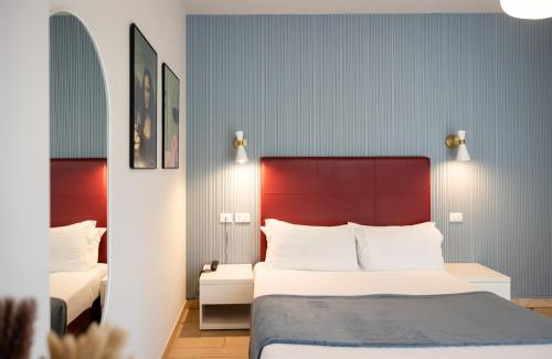 a bedroom with a large bed with a red headboard at Hotel Rossovino Como in Como