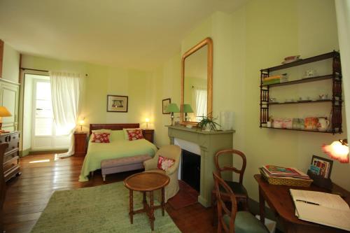 a bedroom with a bed and a table and a desk at Le Masbareau, Chambre et Table d'Hôtes de Charme, B&B in Royères-Saint-Léonard