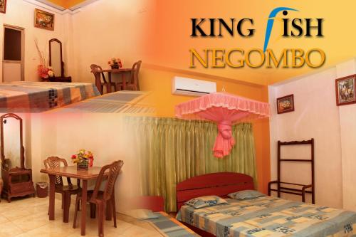 a room with two beds and a table with an umbrella at King Fish Guest House in Negombo