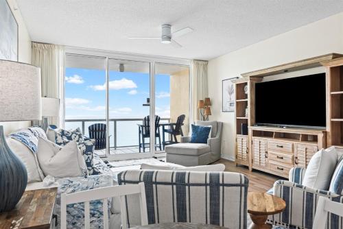 a living room with a couch and a tv at Modern Gulf Front Condo, Pool, 2 Hot Tubs, Platinum Beach Service, Endless Views in Navarre
