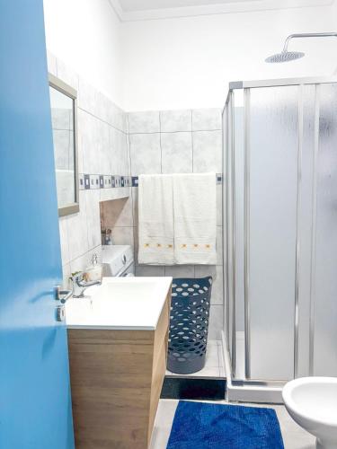 a white bathroom with a shower and a sink at Casa da Pedra in Moledo